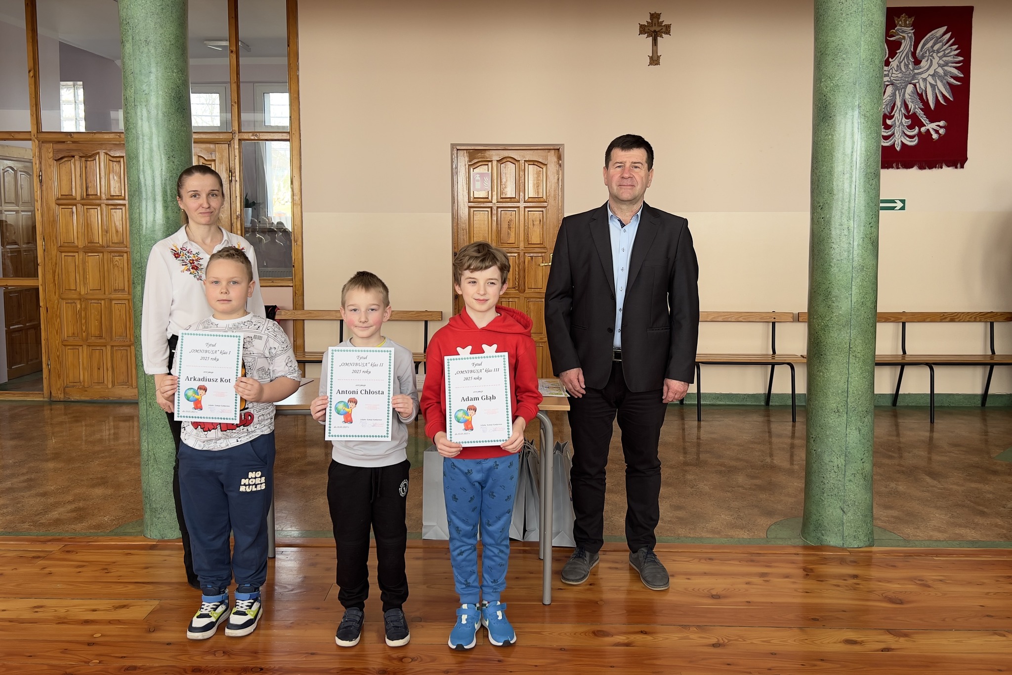 zwycięzcy konkursu trzymający dyplomy wraz z Dyrektorem i organizatorem